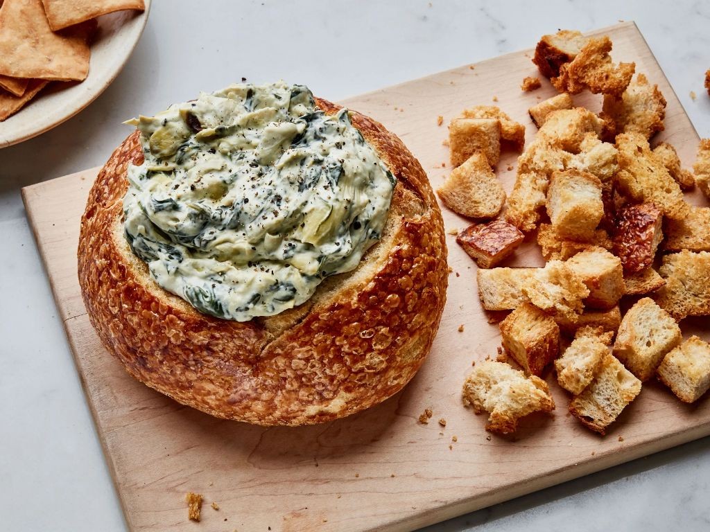 Spinach and artichoke dip served in a bread bowl